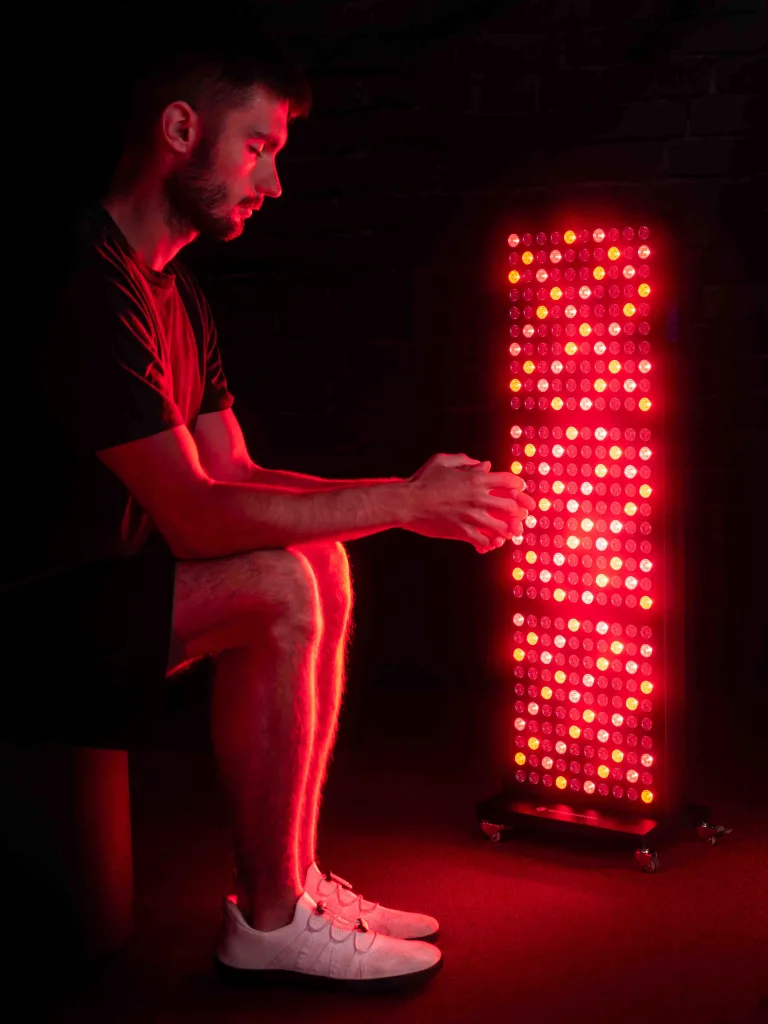 Sitzender Mann bei einer RED- und NIR-Anwendung vor dem Mitochondriak® Maxi am Rollstativ